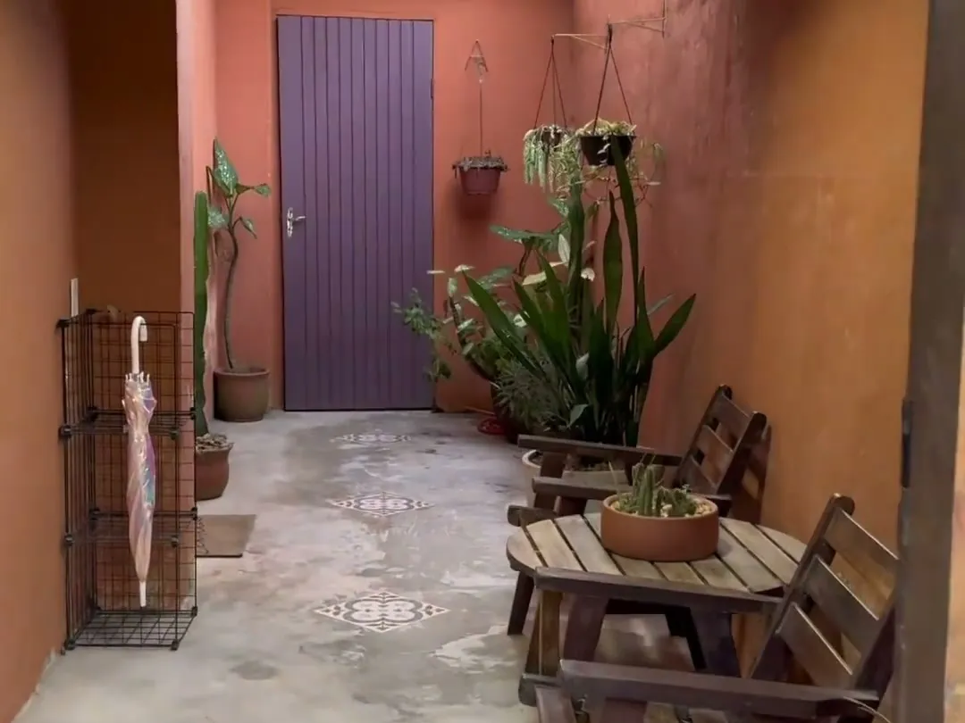 Entrada do Nogueira Pilates, com plantas e bancos de madeira